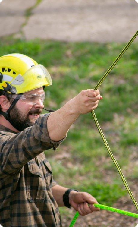 Owner Cameron Audette carefully handling rigging ropes during tree work
